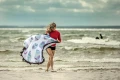 Okrągły ręcznik plażowy Dakota trzymany przez kobietę na plaży